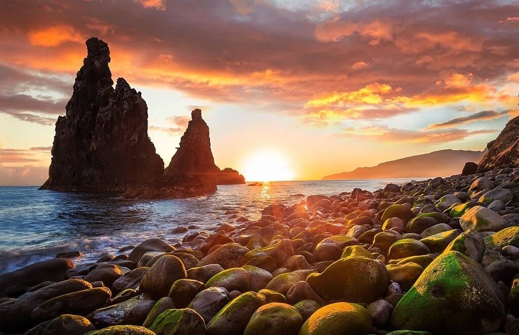 Pôr-do-sol numa das famosas praias de calhau da ilha da Madeira.